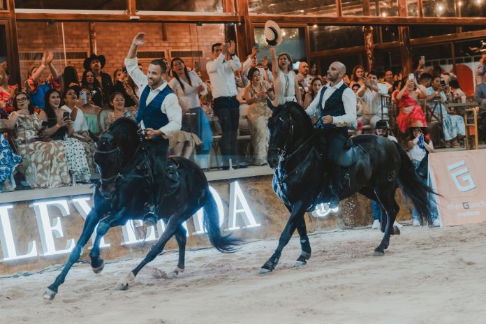 Dos jinetes sobre dos caballos en un espectáculo